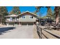 Inviting home featuring a two-car garage, balcony, and a meticulously maintained lawn at 24949 N Mountain Park Dr, Evergreen, CO 80439