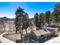 Exterior of property with a small outbuilding and fenced in yard at 24949 N Mountain Park Dr, Evergreen, CO 80439
