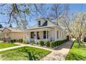Well-maintained brick home featuring a quaint front porch and a beautifully landscaped lawn at 4551 Julian St, Denver, CO 80211