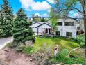 Charming two-story home with a well-maintained lawn, mature trees, and an inviting covered porch at 431 N Harlan St, Lakewood, CO 80226