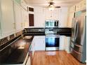 Bright kitchen boasts stainless steel appliances, white cabinetry, and granite countertops at 715 S Alton Way # 10A, Denver, CO 80247