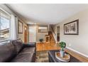 Inviting living area with wood floors, neutral walls, front door, and staircase at 9430 Perry St, Westminster, CO 80031