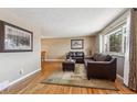 Bright living room features hardwood floors, a comfy sofa, and natural light at 9430 Perry St, Westminster, CO 80031