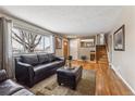 Comfortable living room with hardwood floors, a large window, and a staircase at 9430 Perry St, Westminster, CO 80031