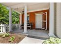 Inviting front porch with classic columns, rocking chairs, and a white picket fence detail at 11791 Bradburn Blvd, Westminster, CO 80031