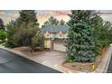 Charming two-story home boasts mature trees, a brick driveway, and a well-maintained yard at 16416 E Powers Pl, Centennial, CO 80015