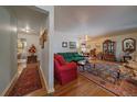 Spacious living room with hardwood floors, patterned rug, and ample seating at 3831 S Hillcrest Dr, Denver, CO 80237