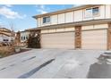 Two-car attached garage with tan doors and brick exterior at 5385 Camargo Rd, Littleton, CO 80123