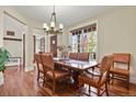 Elegant dining room with a classic chandelier, wood floors, and a view to the front yard at 7947 Monarch Rd, Larkspur, CO 80118