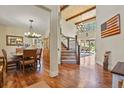 Bright foyer with high ceilings, wood floors, grand staircase, and views into dining and living spaces at 7947 Monarch Rd, Larkspur, CO 80118