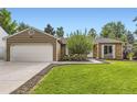 Well-maintained ranch house featuring a green lawn, mature tree, and a convenient two-car garage at 17404 E Prentice Cir, Centennial, CO 80015