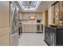 Bright kitchen featuring stainless steel appliances, white cabinetry, and ample counter space, enhanced by a skylight at 13631 E Marina Dr # 109, Aurora, CO 80014