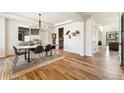 Elegant dining room featuring wood floors, a modern light fixture, and stylish decor at 10968 Lewiston St, Commerce City, CO 80022