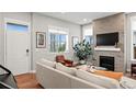 Bright living room with a stone fireplace, large windows, and hardwood floors at 5925 Hanover St, Denver, CO 80238