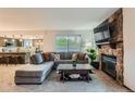 Comfortable living room with sectional sofa, stone fireplace, and an open layout to kitchen at 9556 W 89Th Cir, Broomfield, CO 80021