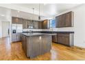 Modern kitchen featuring stainless steel appliances, a large island, and hardwood floors at 497 Valley Way, Bennett, CO 80102