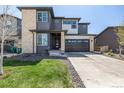Modern two-story home with stone accents, gray siding, well maintained lawn, and a two car garage on a sunny day at 23652 E 40Th Ave, Aurora, CO 80019