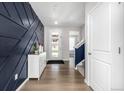 Welcoming foyer with stylish navy accent wall, light wood floors, and a view of the staircase at 23652 E 40Th Ave, Aurora, CO 80019