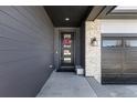 Inviting entryway with stone accents, dark wood siding, and a modern glass front door with a festive wreath at 23652 E 40Th Ave, Aurora, CO 80019