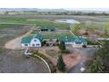 Extensive property with multiple structures, a pond, white fencing, and mature landscaping, set amidst vast open fields at 6231 Prospect Rd, Longmont, CO 80503