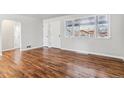 Bright living room featuring beautiful hardwood floors, fresh paint, and natural light from a large window at 1665 Yukon St, Lakewood, CO 80214