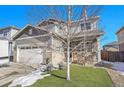 Two-story house with gray siding, brick accents, and a landscaped front yard at 7888 Tejon St, Denver, CO 80221