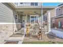 Inviting covered porch with charming decor including flowers, wagon wheels, and a decorative fountain at 7888 Tejon St, Denver, CO 80221