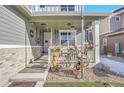 Front porch with hanging wind chimes and decorative wheelbarrow at 7888 Tejon St, Denver, CO 80221