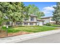 Landscaped front yard with mature trees enhancing this charming home's curb appeal at 16025 E Warren Pl, Aurora, CO 80013