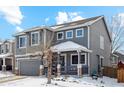 Two-story house with gray siding, covered porch, and attached garage at 5149 S Malta Way, Centennial, CO 80015