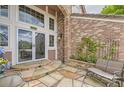 Stone patio leading to the front door with transom windows and brick facade at 7758 Edgewater Ct, Lone Tree, CO 80124