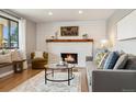 Bright living room featuring a cozy fireplace, hardwood floors, and ample natural light at 1667 S Balsam Ct, Lakewood, CO 80232