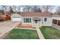 Charming single-Gathering home with a detached garage and green lawn at 415 S Parfet St, Lakewood, CO 80226