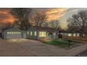 Charming single-Gathering home with a detached garage and green lawn at sunset at 415 S Parfet St, Lakewood, CO 80226