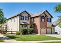 Attractive two-story home with a combination brick and siding facade and attached garage at 11951 Singing Winds St, Parker, CO 80138