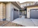 Two-car garage and entryway with stone accents and lighting at 11099 Pastel Pt, Parker, CO 80134