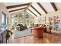 Bright living room with vaulted ceilings, exposed beams, large windows, and hardwood floors at 1555 Genesee Ridge Rd, Golden, CO 80401