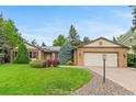 Charming brick home with mature landscaping, a well-manicured lawn, and an attached two-car garage at 9939 E Aberdeen Ave, Englewood, CO 80111