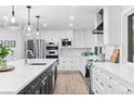 Spacious kitchen with stainless steel appliances, white cabinets, and a large island with quartz countertops at 9939 E Aberdeen Ave, Englewood, CO 80111