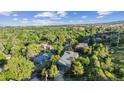 Aerial view of home in a neighborhood of lush green trees with blue skies and a mountain view at 14150 Foothill Ln, Golden, CO 80401