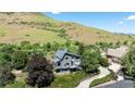 Aerial view of modern home with lush landscaping and a winding driveway at 14150 Foothill Ln, Golden, CO 80401