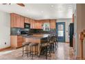 Spacious kitchen with an island, bar seating, ample cabinets, and black appliances at 8679 Apache Plume Dr, Parker, CO 80134