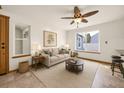Bright living room with neutral tones, fan, and ample natural light at 8679 Apache Plume Dr, Parker, CO 80134