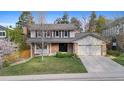 Attractive two-story home with a well-maintained lawn, brick accents, and an attached two-car garage at 8132 Lodgepole Trl, Lone Tree, CO 80124