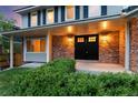 Inviting front porch with brick accents, updated lighting, and manicured shrubbery enhancing curb appeal at 8132 Lodgepole Trl, Lone Tree, CO 80124