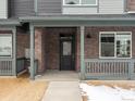 Inviting brick front porch with sturdy railings and sleek black front door entrance at 6571 N Malaya St, Aurora, CO 80019