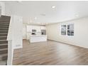 Spacious living room with hardwood floors leading into a modern kitchen with stainless appliances at 6571 N Malaya St, Aurora, CO 80019