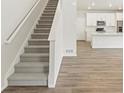 Elegant staircase with plush carpet and a bright, open floor plan to the kitchen at 6571 N Malaya St, Aurora, CO 80019