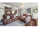 Inviting living room with plush leather seating and an open view to the kitchen at 12167 E Exposition Ave, Aurora, CO 80012
