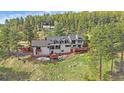 Aerial view of a home with spacious deck, surrounded by lush greenery at 25601 Centennial Trl, Golden, CO 80401
